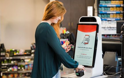 Mapco store woman scanning phone at self checkout
